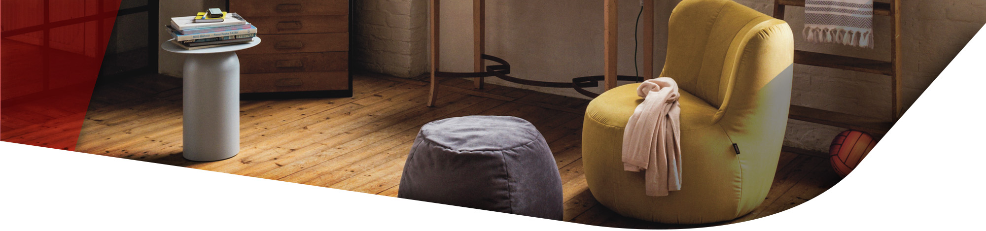 Gelber Sessel in Gummibärform mit passendem Hocker in einem Raum mit Holzfußboden stehend. 